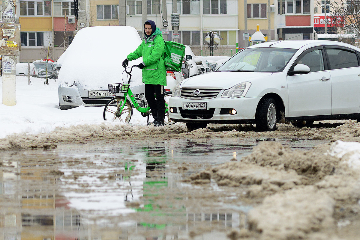 Краснодар, 7 февраля 2021 года: курьер на улице после снегопада. С вечера 6 февраля в городе шел дождем со снегом, аэропорт города закрыт