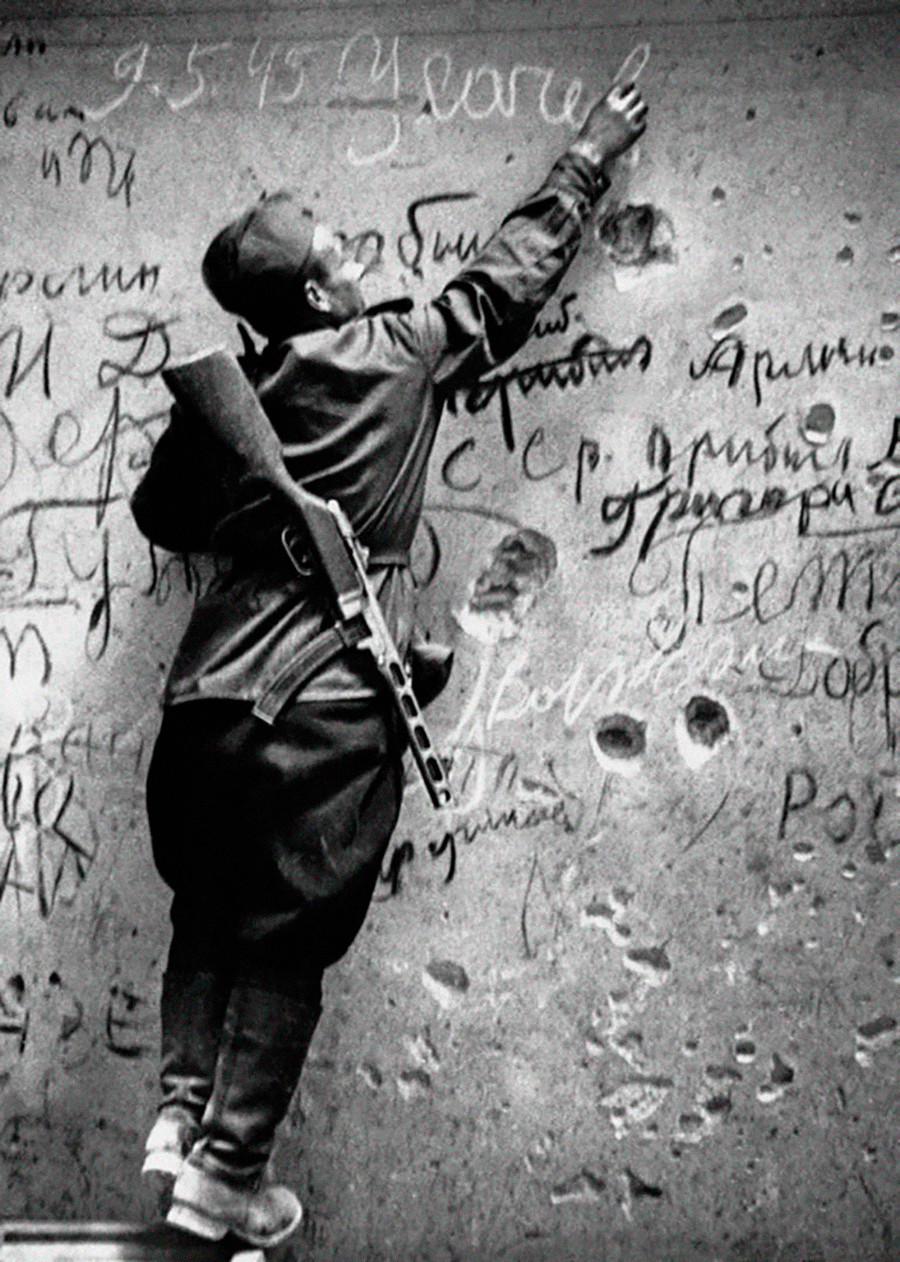 Un soldat soviétique laissant une signature sur le mur du Reichstag
