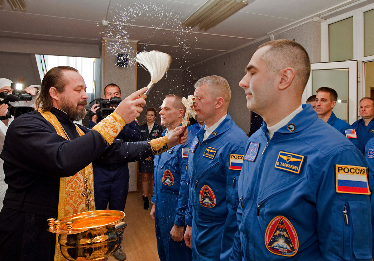 Ein orthodoxer Priester segnet die Mitglieder der nächsten Expedition zur Internationalen Raumstation, den US-Astronauten Kevin Ford (links) und die beiden russischen Kosmonauten Oleg Nowitskij (Mitte) und Jewgeni Tarelkin (rechts).