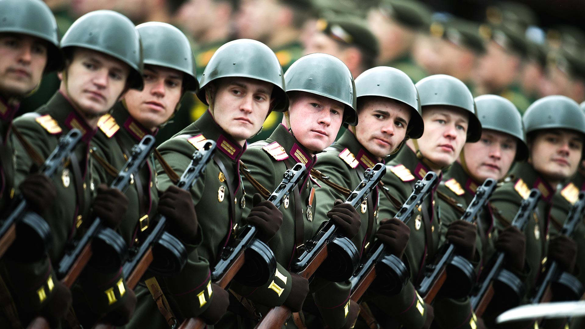 Des militaires russes traversant la place Rouge en portant des uniformes soviétiques de la Seconde Guerre mondiale et des mitraillettes PPSh.
