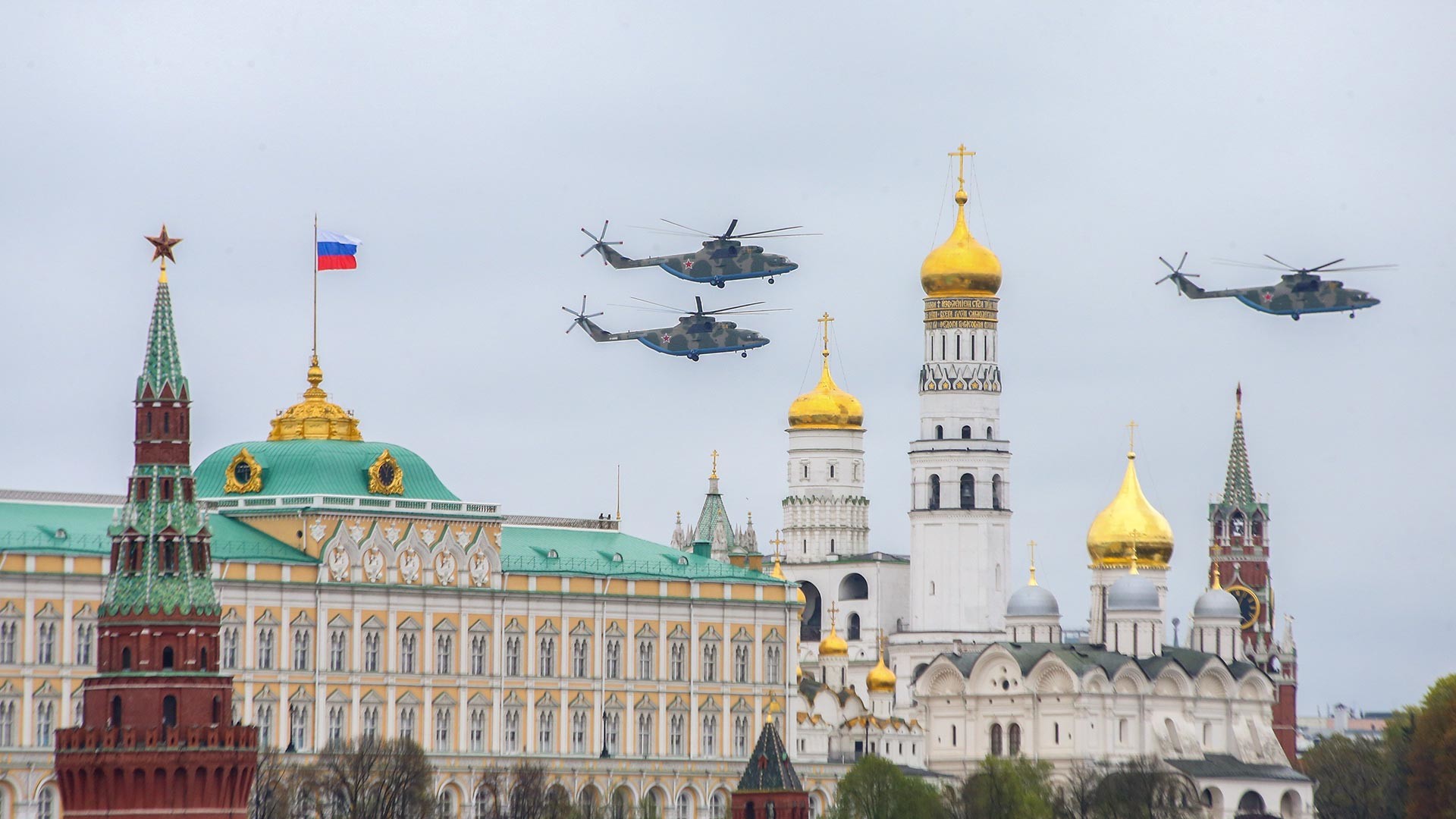 Des hélicoptères de transport lourds russes Mi-26 survolant la place Rouge. Ces oiseaux de fer sont utilisés par des opérateurs militaires et civils, et s’avèrent les hélicoptères les plus grands et les plus puissants à avoir été produits en série.