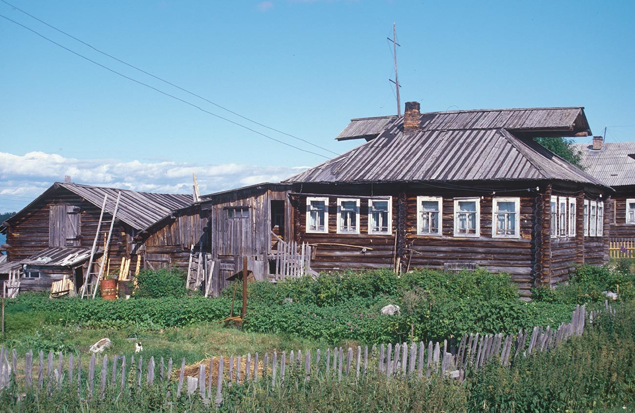Kovda. Maison en rondins et grange. Notez les pignons à capuchon sur le toit de la maison. Photographie: William Brumfield. 24 juillet 2001