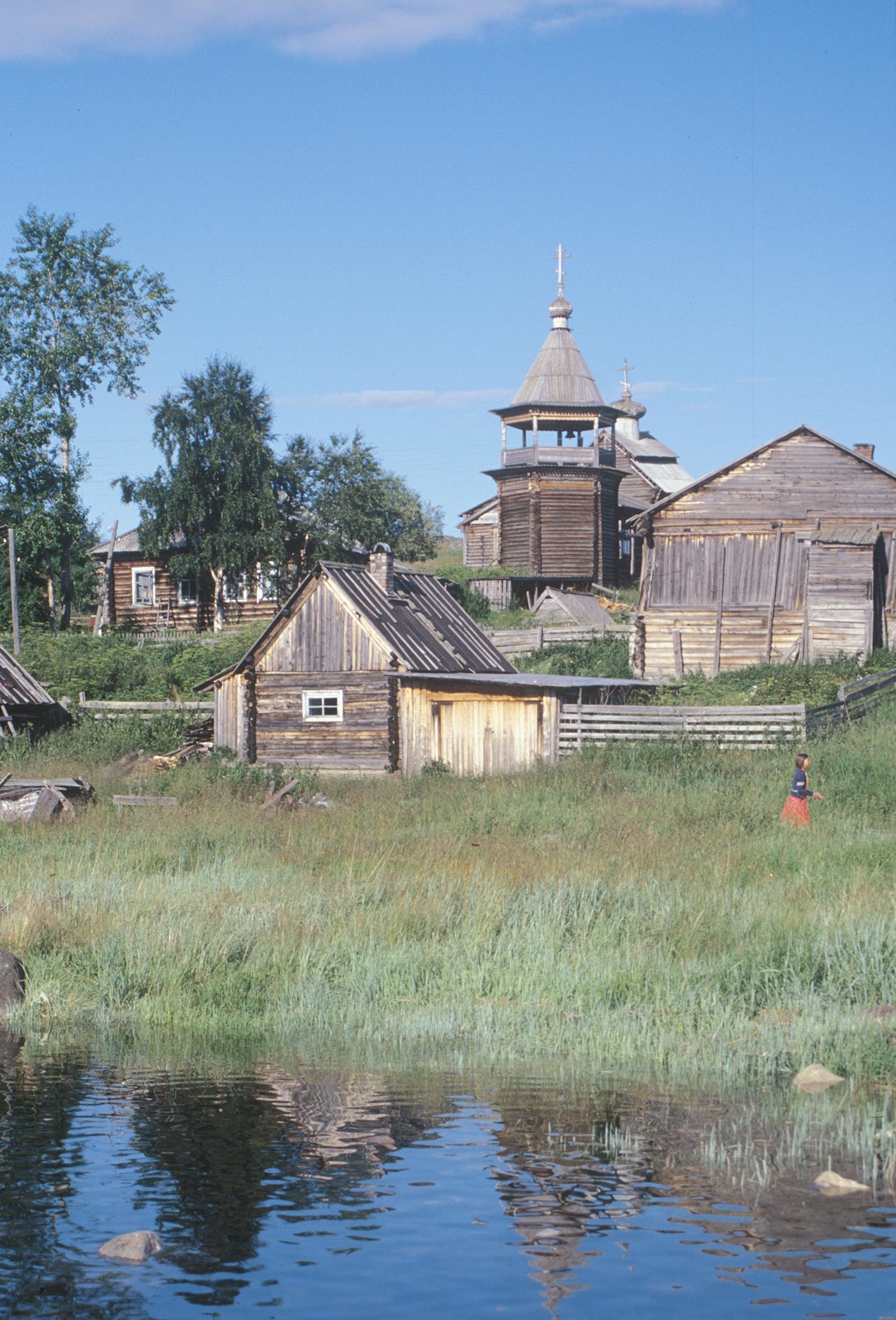 Kovda. Maison en rondins, bania et grange. Arrière-plan: clocher et église Saint-Nicolas. Photographie: William Brumfield. 24 juillet 2001