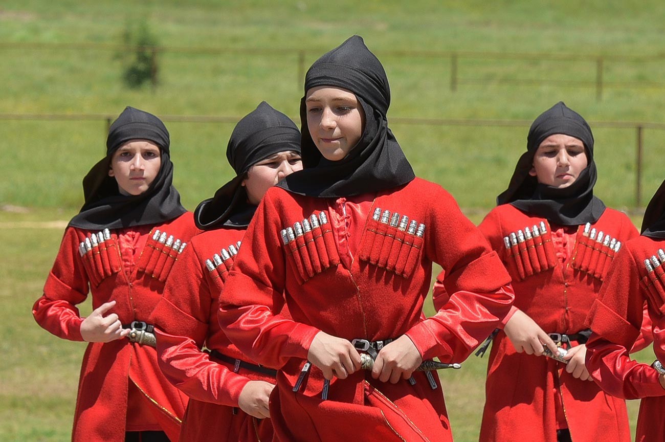 Des membres d'un collectif de danse se produisent pendant une course de chevaux en Abkhazie