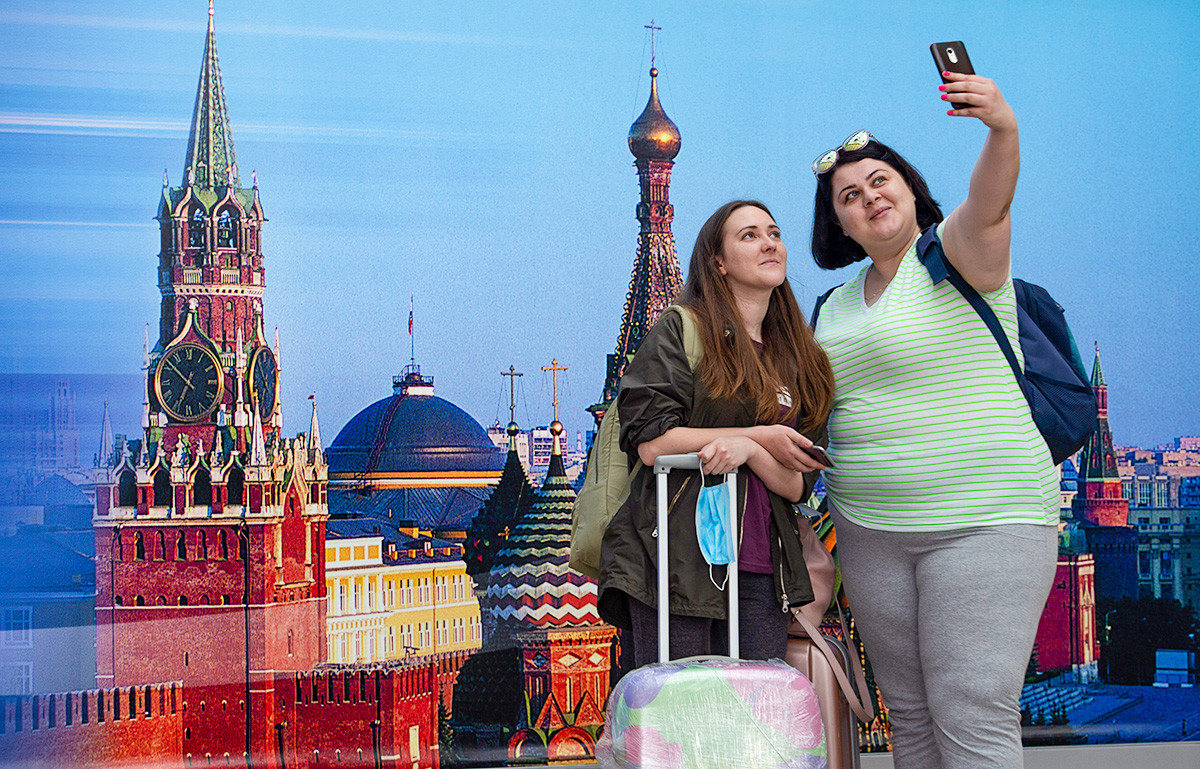 Passengers take a selfie at the Sheremetyevo International Airport in Moscow, Russia