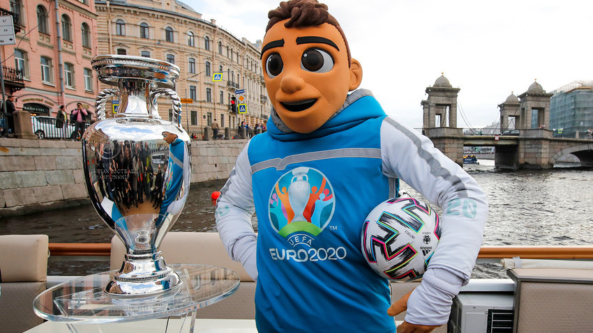 Maskota Evropskega prvenstva v nogometu 2020 Skillzy pozira s trofejo EURO 2020 med vožnjo z ladjo po reki Fontanki med uradno trofejno turnejo EURO 2020 v Sankt Peterburgu v Rusiji, v soboto, 22. maja 2021. Sankt Peterburg bo gostil sedem preloženih tekem iz EURO 2020, vključno s četrtfinalom.
