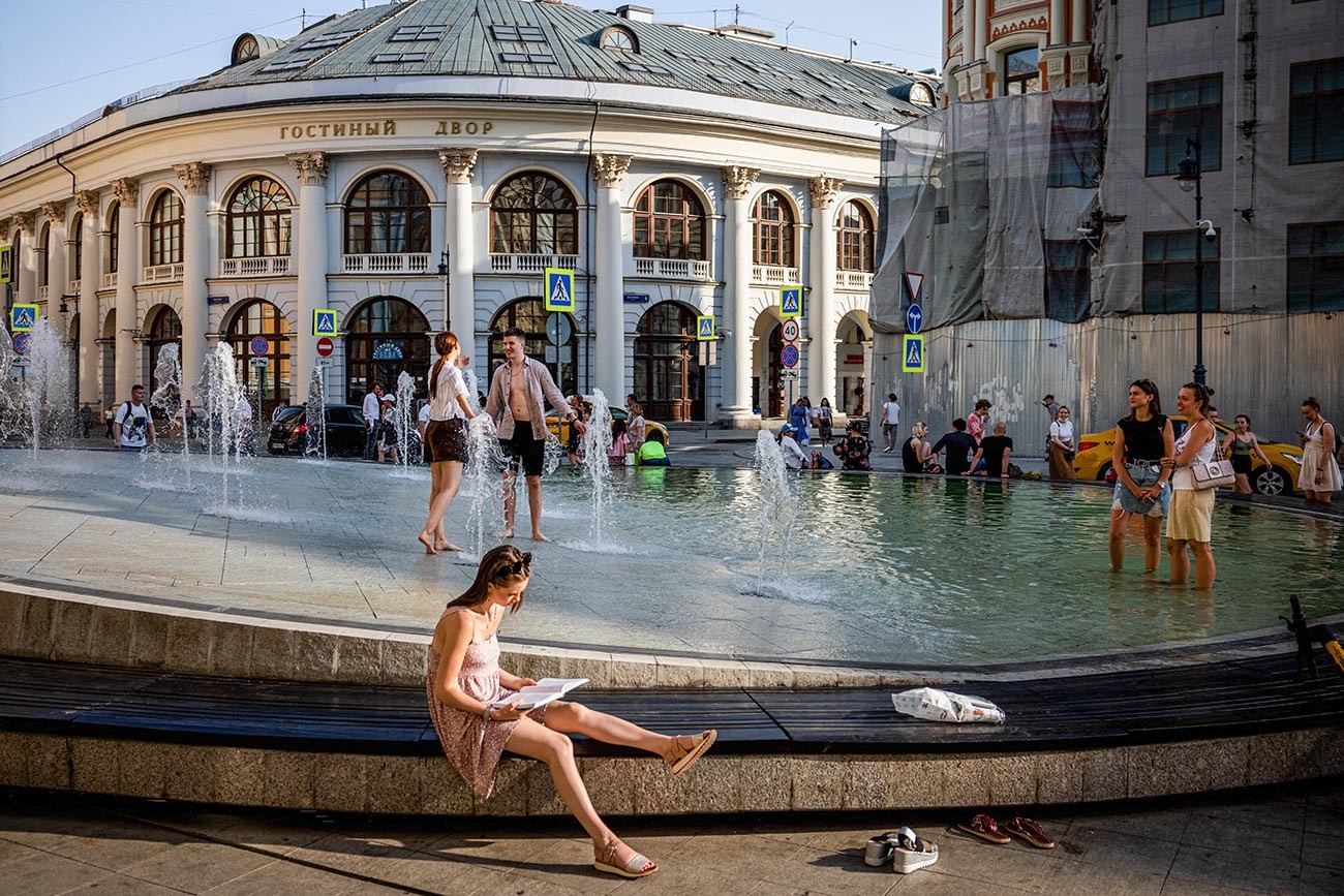 La gente si rinfresca in una fontana durante una calda giornata estiva nel centro di Mosca, 22 giugno 2021