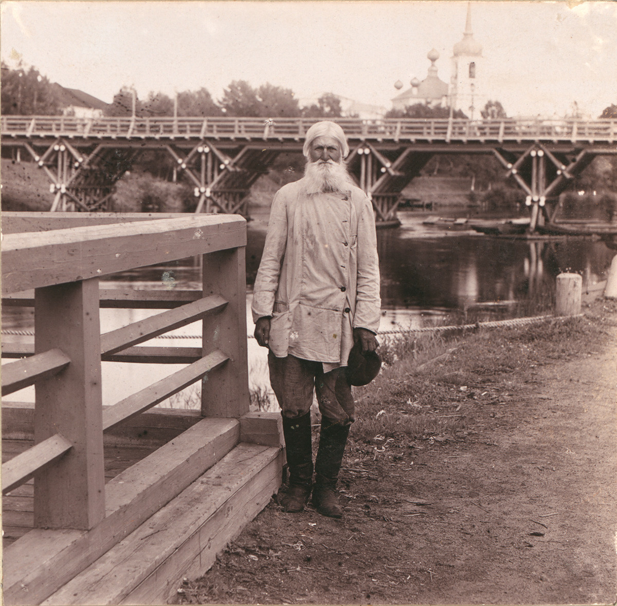 Vytegra. Local villager on background of Sivers Bridge & Resurrection Cathedral. Summer 1909