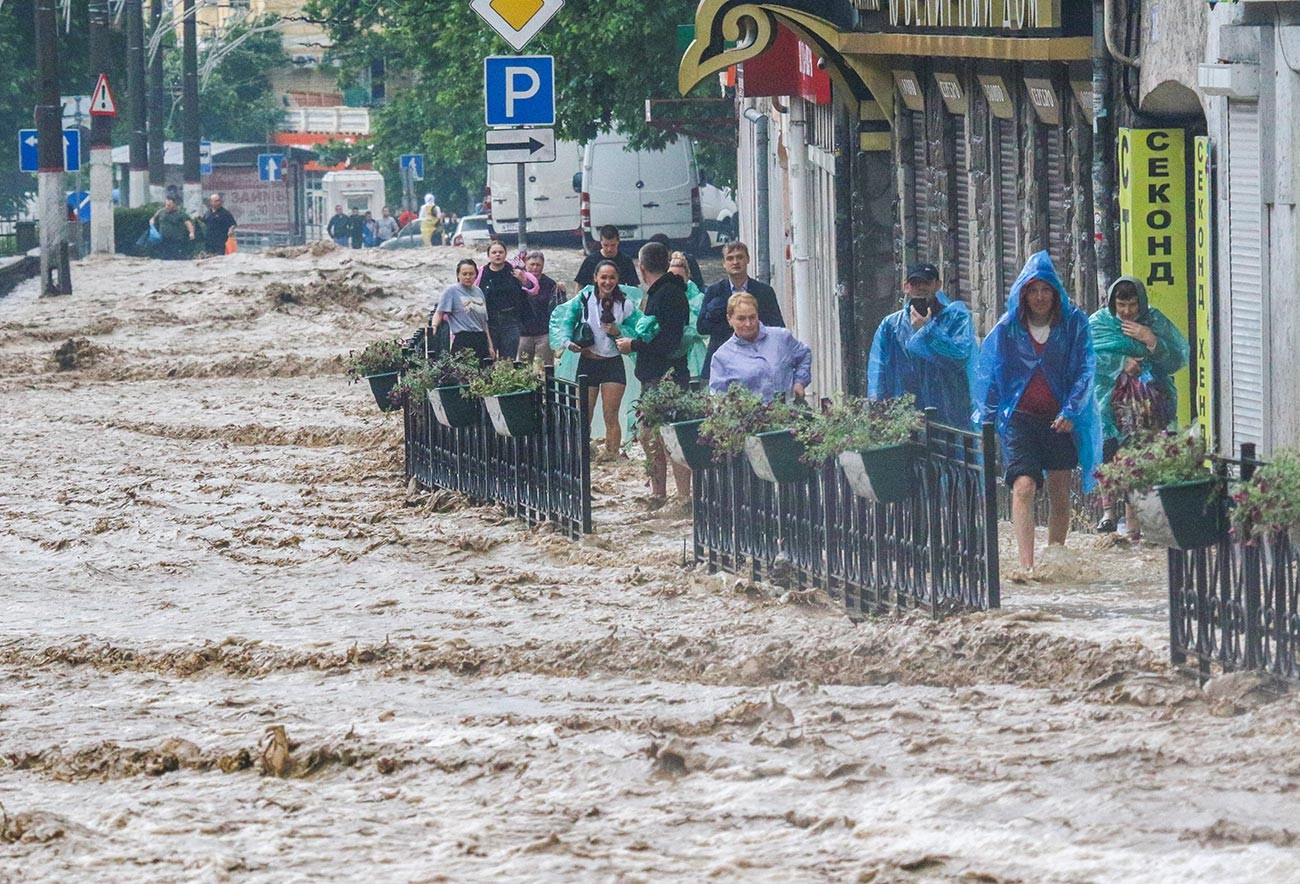 Хората на наводнена улица след обилните валежи в Ялта