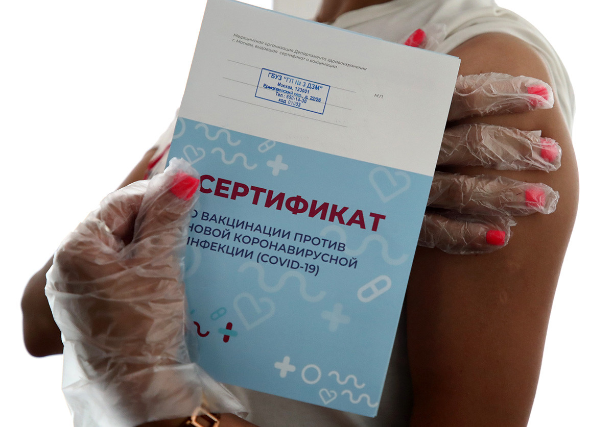 Женщина получала сертификат после инъекции вакцины COVID-19 в павильоне 