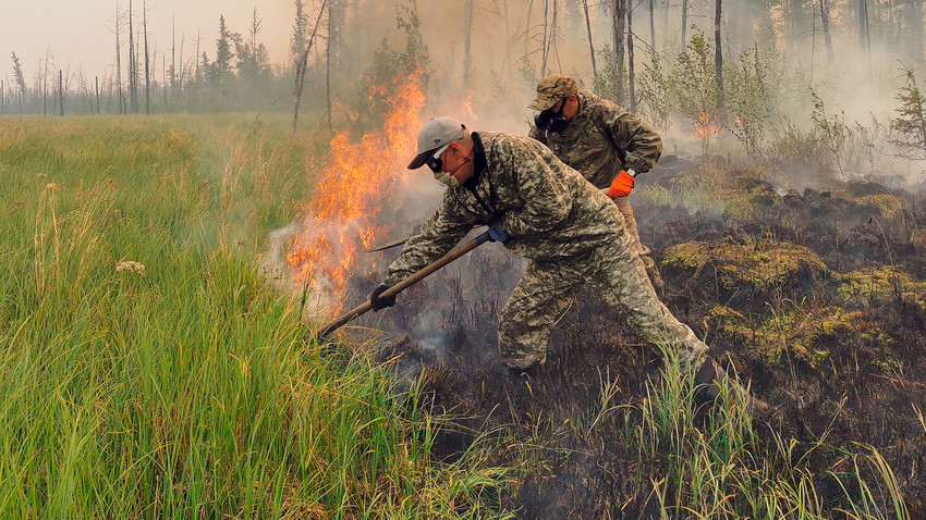 Voluntários apagam incêndio florestal na república da Iakútia, 17 de julho de 2021