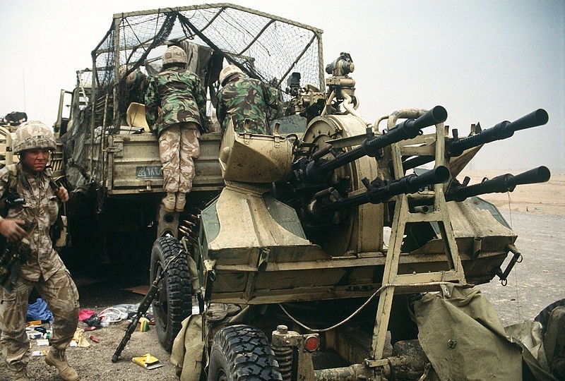 Soldados británicos examinan el contenido de un camión de transporte iraquí en la autopista Basora-Kuwait, cerca de la ciudad de Kuwait, tras la retirada de las fuerzas iraquíes durante la operación Tormenta del Desierto (1991). Detrás del camión hay un cañón antiaéreo iraquí ZPU-4.