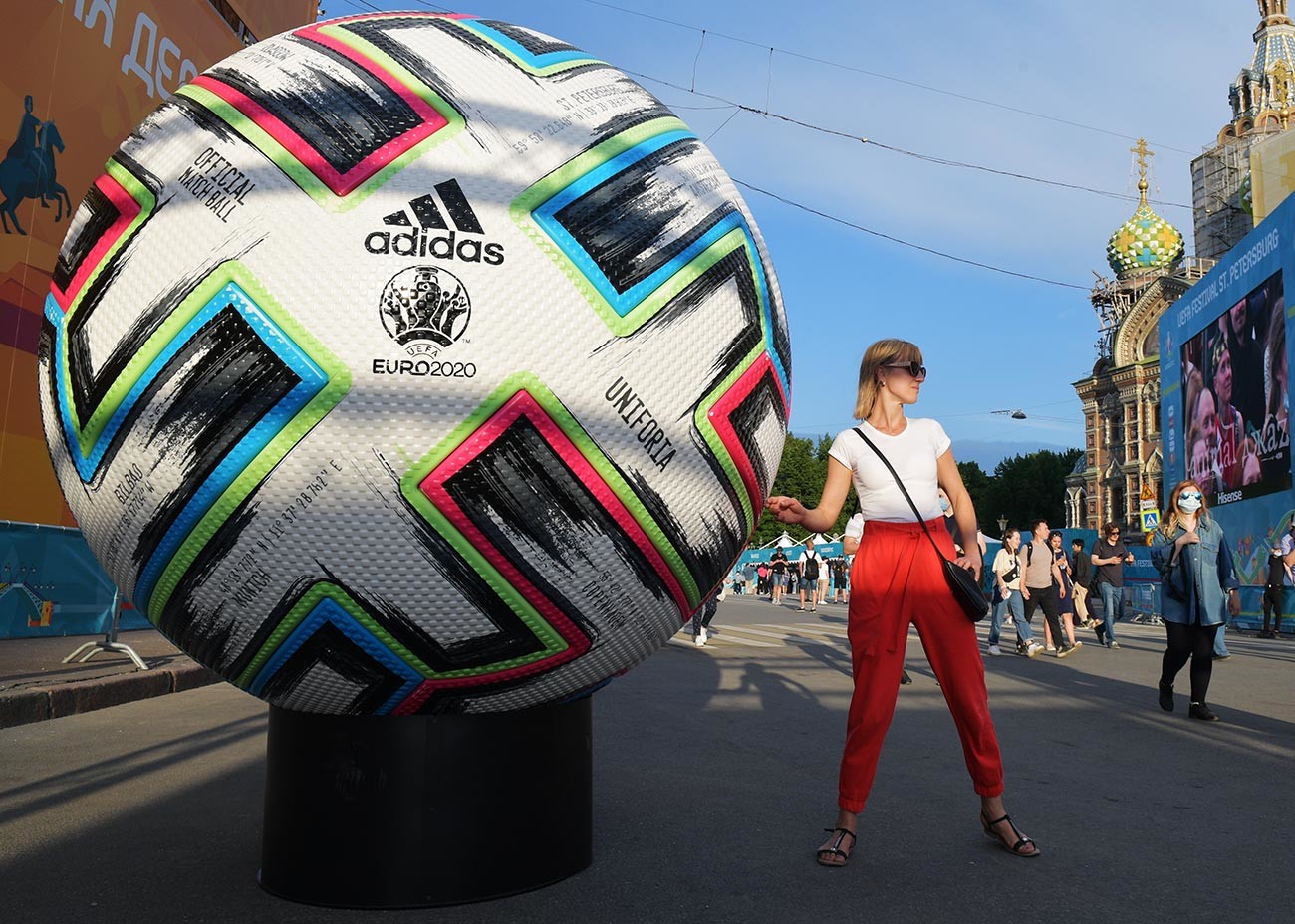 A girl is photographed next to a copy of the official ball of the 2020 European Football Championship in the fan zone on Konyushennaya Square in St. Petersburg.