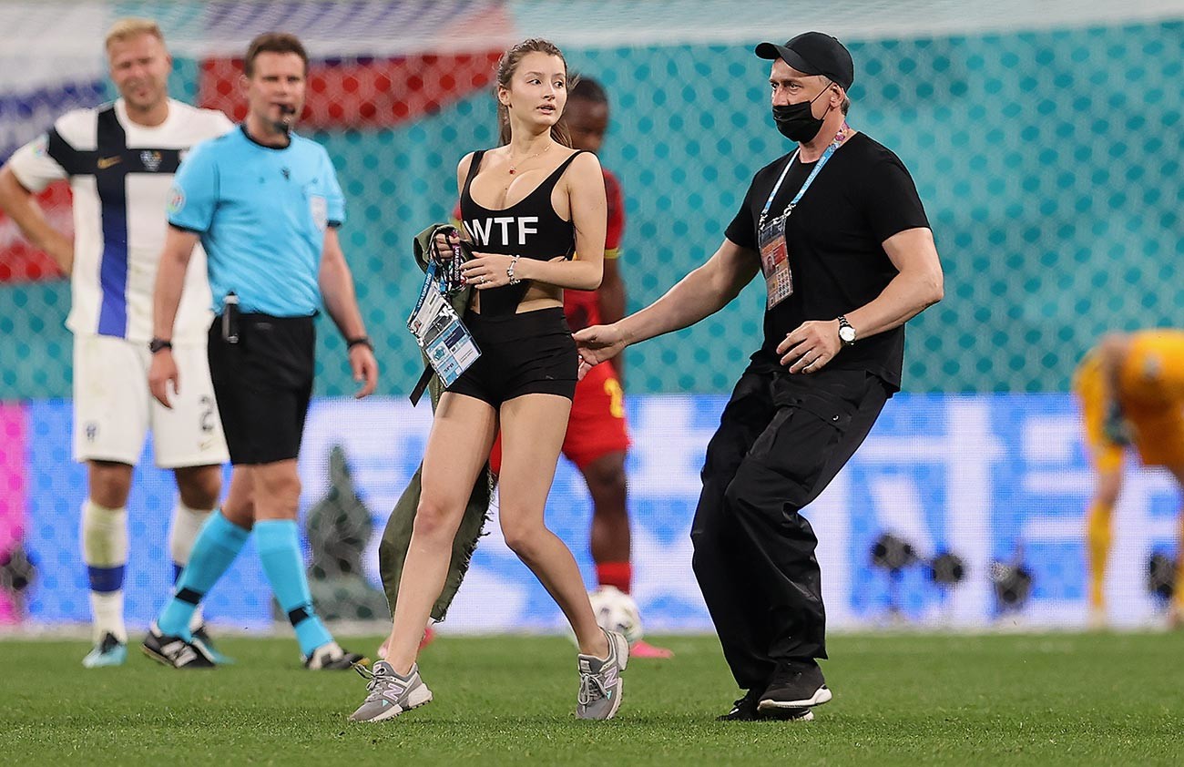 A pitch invader is removed from the pitch by ground staff during the UEFA Euro 2020 Championship Group B match between Finland and Belgium at Saint Petersburg Stadium on June 21, 2021 in Saint Petersburg, Russia.