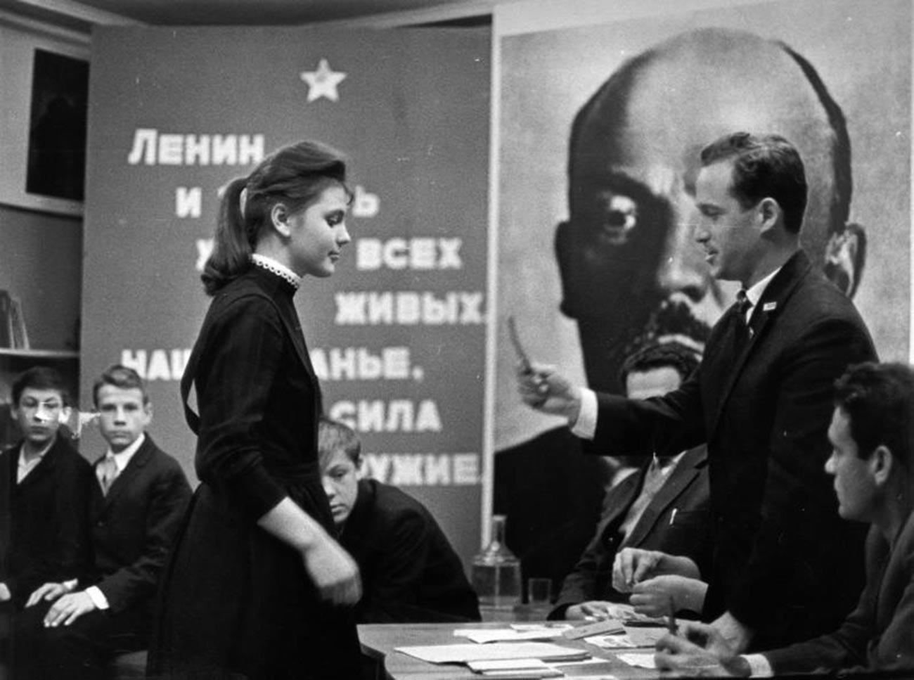 Seorang gadis menerima kartu keanggotaan Komsomol.