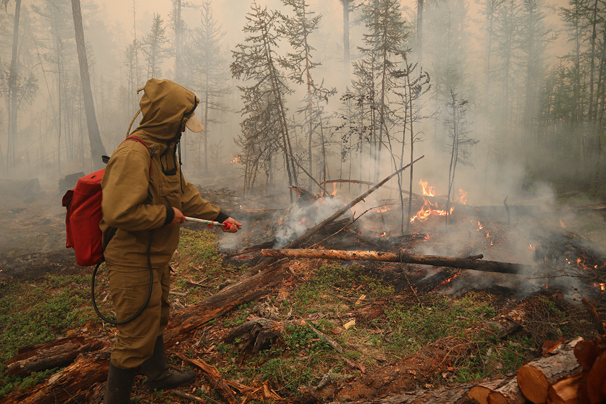 Un spécialiste de la protection forestière travaille à l'extinction d'un incendie près du village de Magaras, en Iakoutie, le 17 juillet