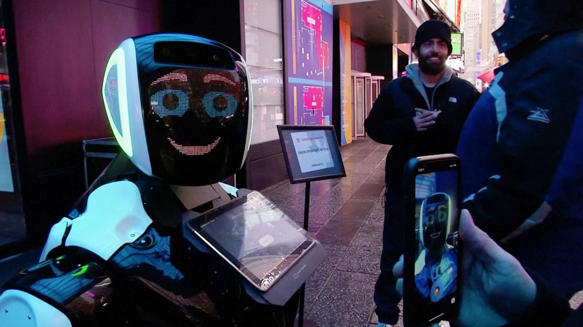 Минувачи на Тајмс сквер комуницираат со роботот Промобот кој ја информира јавноста за симптомите на коронавирусот и спречување на негово ширење. Снимка од видео. Њујорк.

