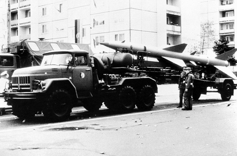 Vista da lateral esquerda de um míssil superfície-ar (SAM) SA-2 Guideline montado em um caminhão de transporte Zil-131 do Exército da Alemanha Oriental
