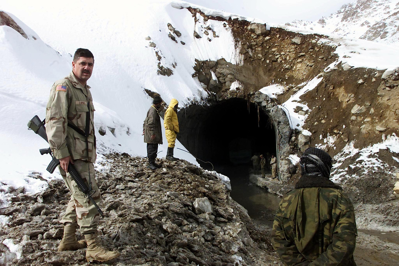 Un soldado estadounidense vigila a los trabajadores afganos que despejan la entrada sur del túnel de Salang para ampliar su acceso.