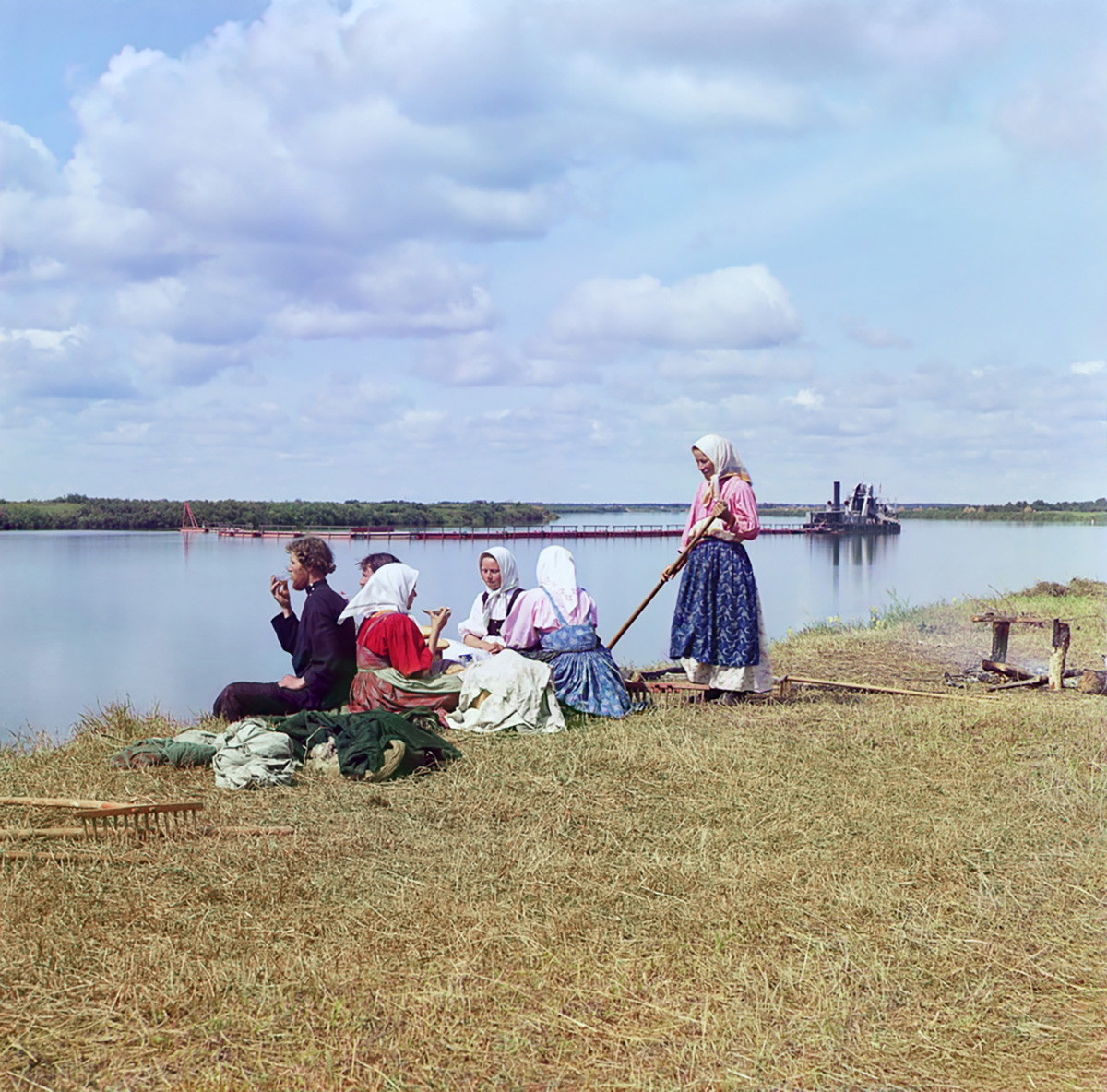Région de Tcherepovets. Paysans buvant du thé pendant une pause lors de la collecte du foin sur une île de la rivière Cheksna. Arrière-plan : barge de dragage pour le chenal de navigation