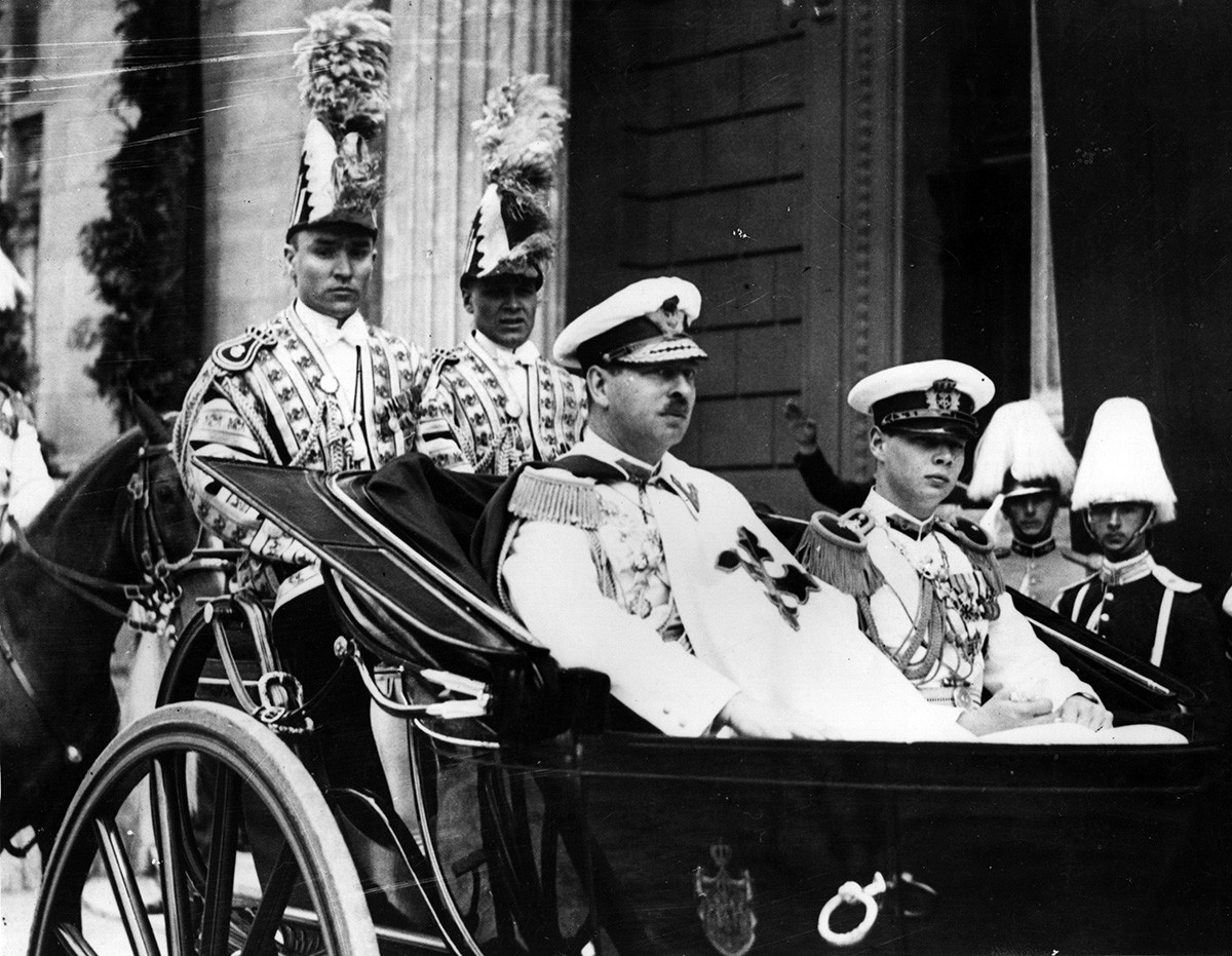 Juni 1939: Carol II. (1893 - 1953), König von Rumänien von 1930 bis 1940, unterwegs zur Eröffnung des neuen Parlaments in einer offenen Kutsche mit Kronprinz Michael, dem späteren König Michael von Rumänien.