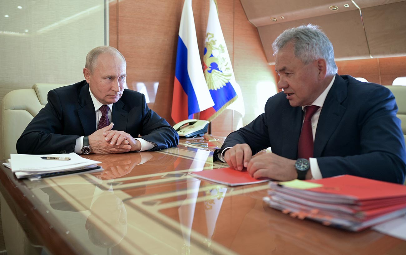 Vladimir Poutine et le ministre russe de la Défense Sergueï Choïgou (à droite) lors d'une réunion à bord de l'avion présidentiel