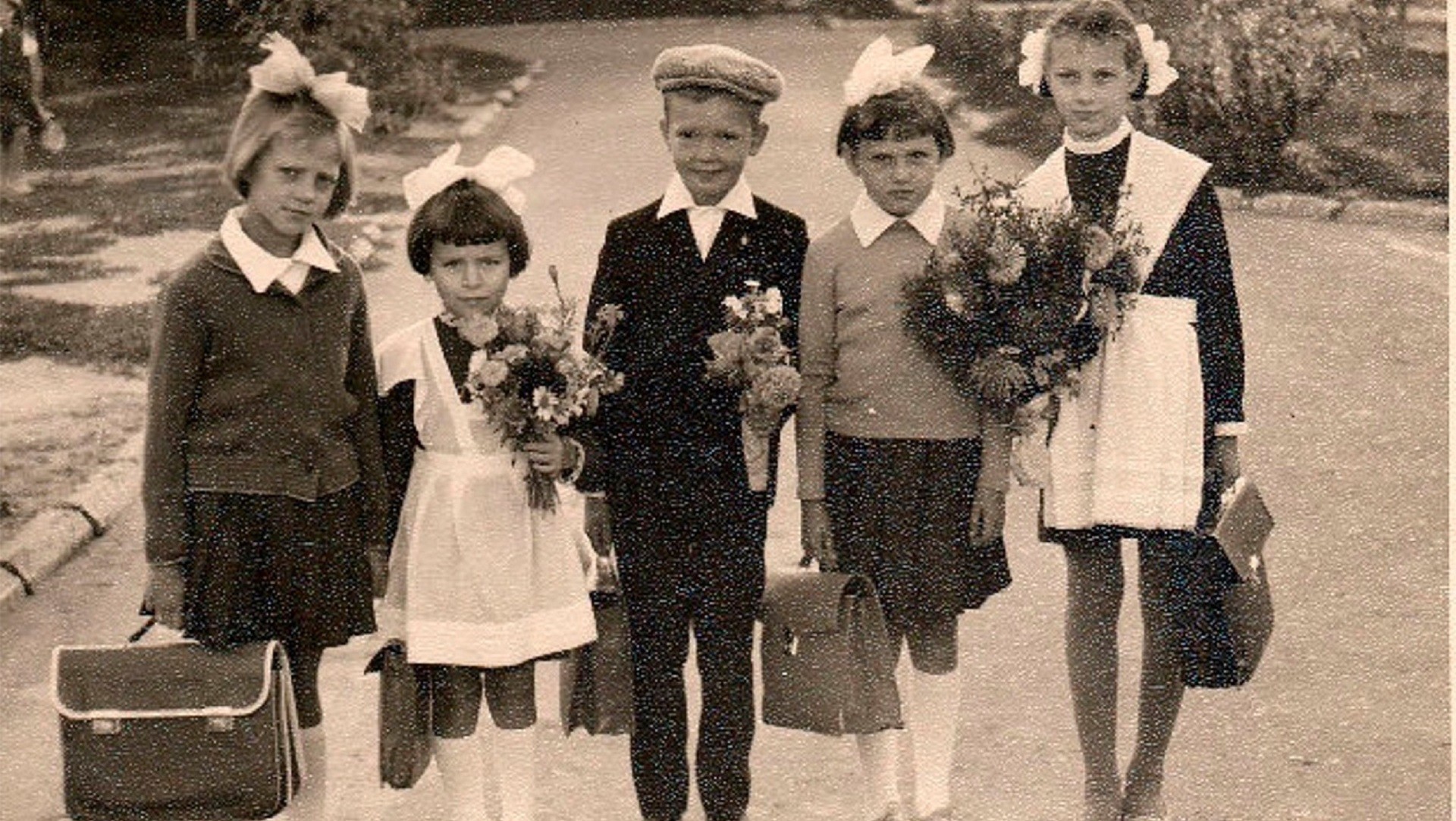 Crianças vestindo o clássico uniforme soviético.