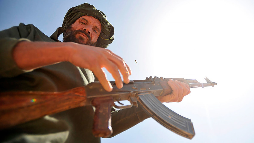 Регрут авганистанске локалне полиције спрема се да пуца из АК-47, провинција Забул, Авганистан.