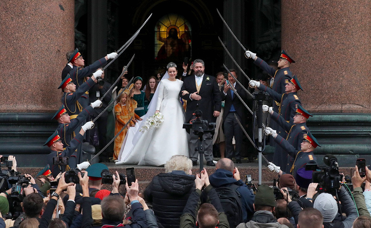 The newlyweds and the bizzare sabre arch.