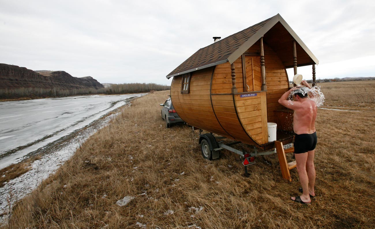 Un uomo fa la doccia fredda, come da tradizione, dopo il bagno di vapore in una banya mobile sulle rive del fiume Tuba, vicino al villaggio di Kochergino, circa 460 km a sud-est della città siberiana di Krasnoyarsk. 1 dicembre 2013