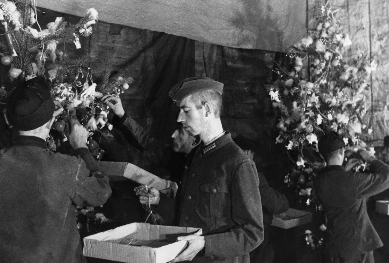 Propagandni posnetek iz sovjetskega taborišča za ujetnike, 1944. Ujeti nemški vojaki krasijo božično drevo v taboriščnem klubu.
