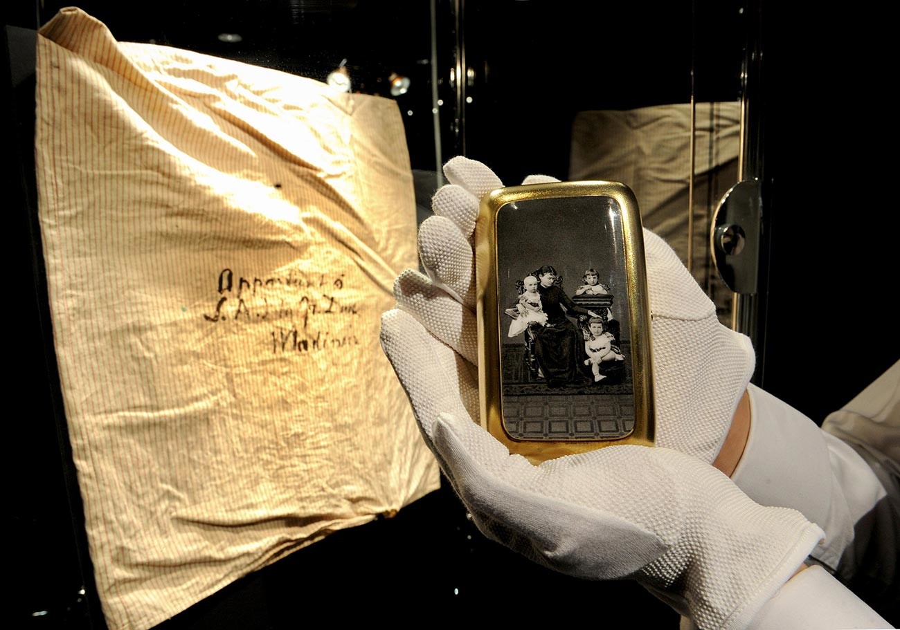 A cigarette case showing the Grand Duchess and grandchildren is seen beside a pillowcase in which the lots were smuggled out of Russia, displayed during the preview of 'Romanov Heirlooms: The lost Inheritance of the Grand Duchess Maria Pavlovna' at Sotheby's, London.