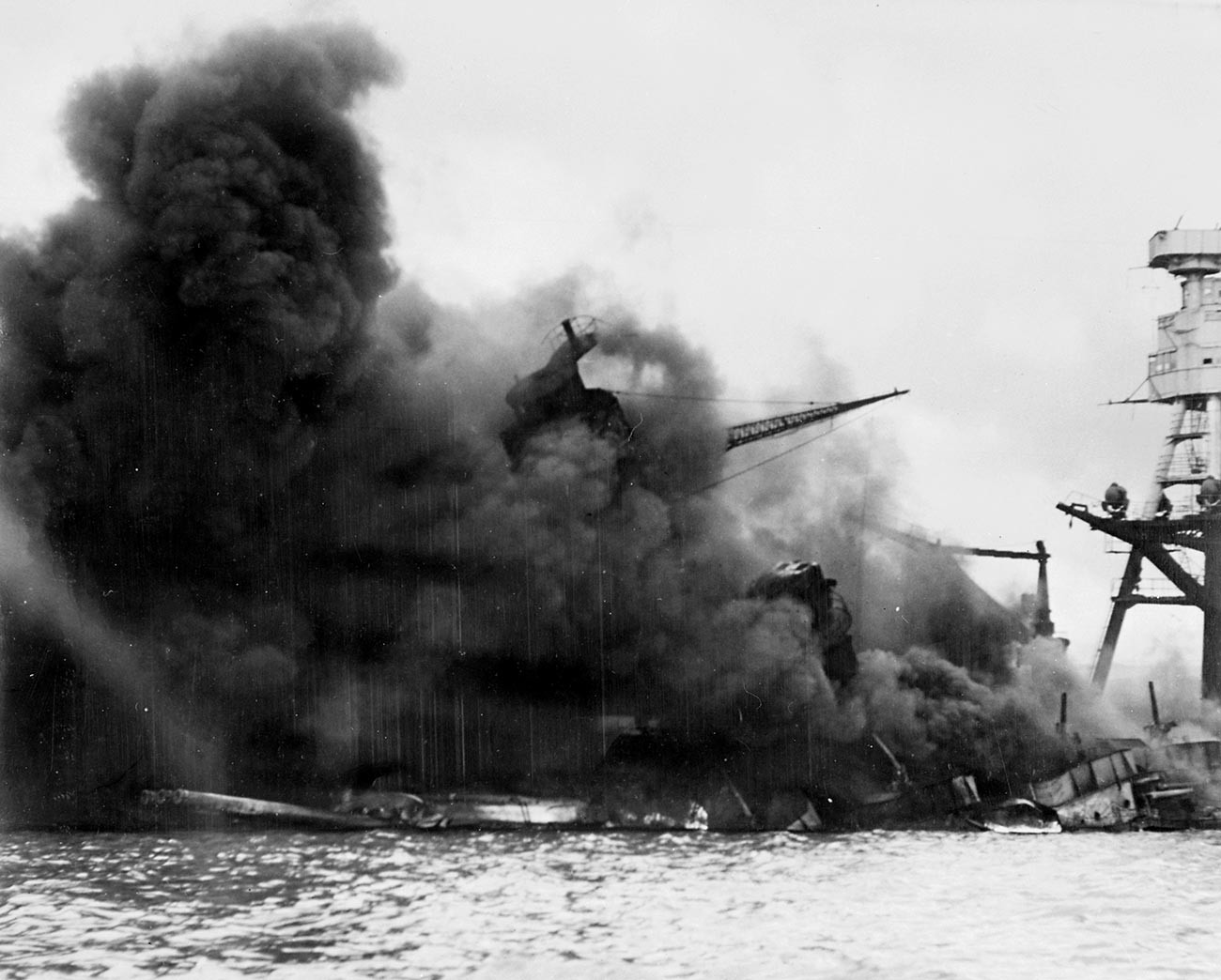Ameriška bojna ladja USS Arizona v ognju po eksploziji na skladišču streliva, na katerega je padla japonska bomba.


