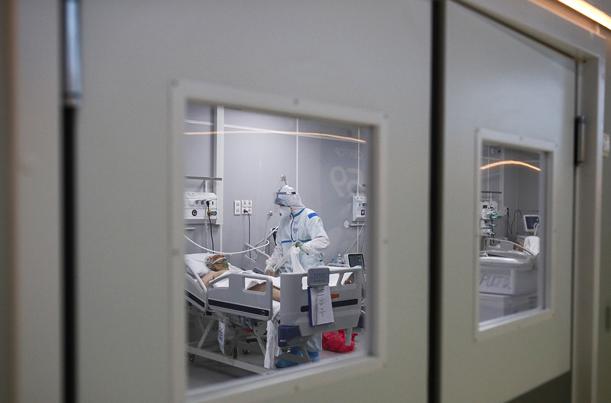 Ein medizinischer Mitarbeiter behandelt einen Patienten in einer Einheit eines temporären COVID-19-Krankenhauses im Sokolniki Exhibition and Convention Center. Moskau, April 2021.