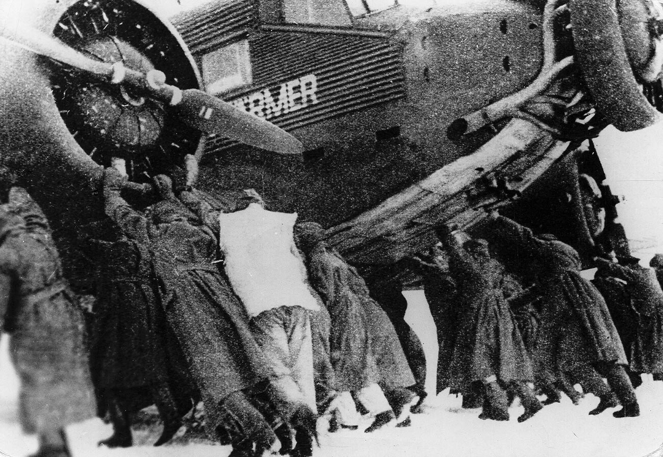 Deutsche Soldaten schieben ein Junkers-52-Flugzeug durch den Schnee auf dem eroberten sowjetischen Flugplatz Pitomnik während der Schlacht von Stalingrad im Zweiten Weltkrieg, Januar 1943.
