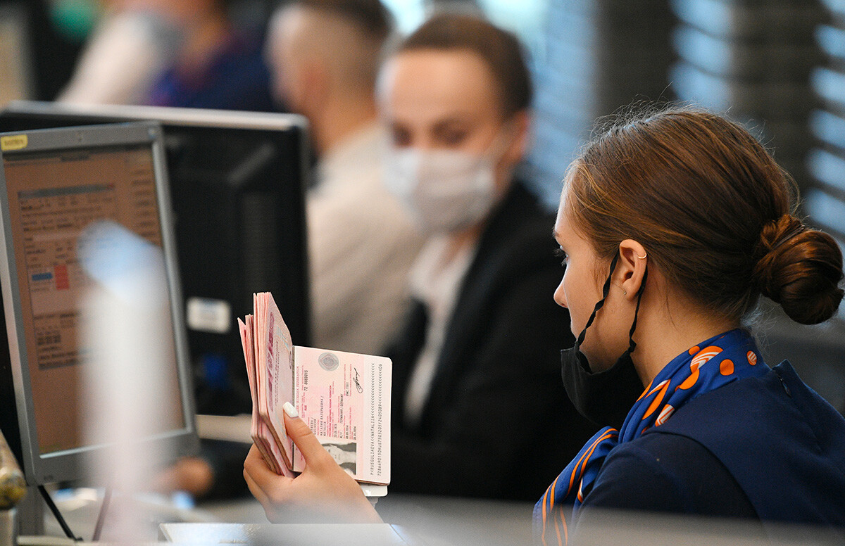 Eine Mitarbeiterin überprüft die Dokumente des Passagiers am Check-in-Schalter am Flughafen Sheremetjewo außerhalb von Moskau, Russland. Die Flüge zu ägyptischen Resorts wurden wieder aufgenommen: Auf jeder der Strecken werden fünf Flüge pro Woche nach Hurghada und Sharm el-Sheikh durchgeführt.