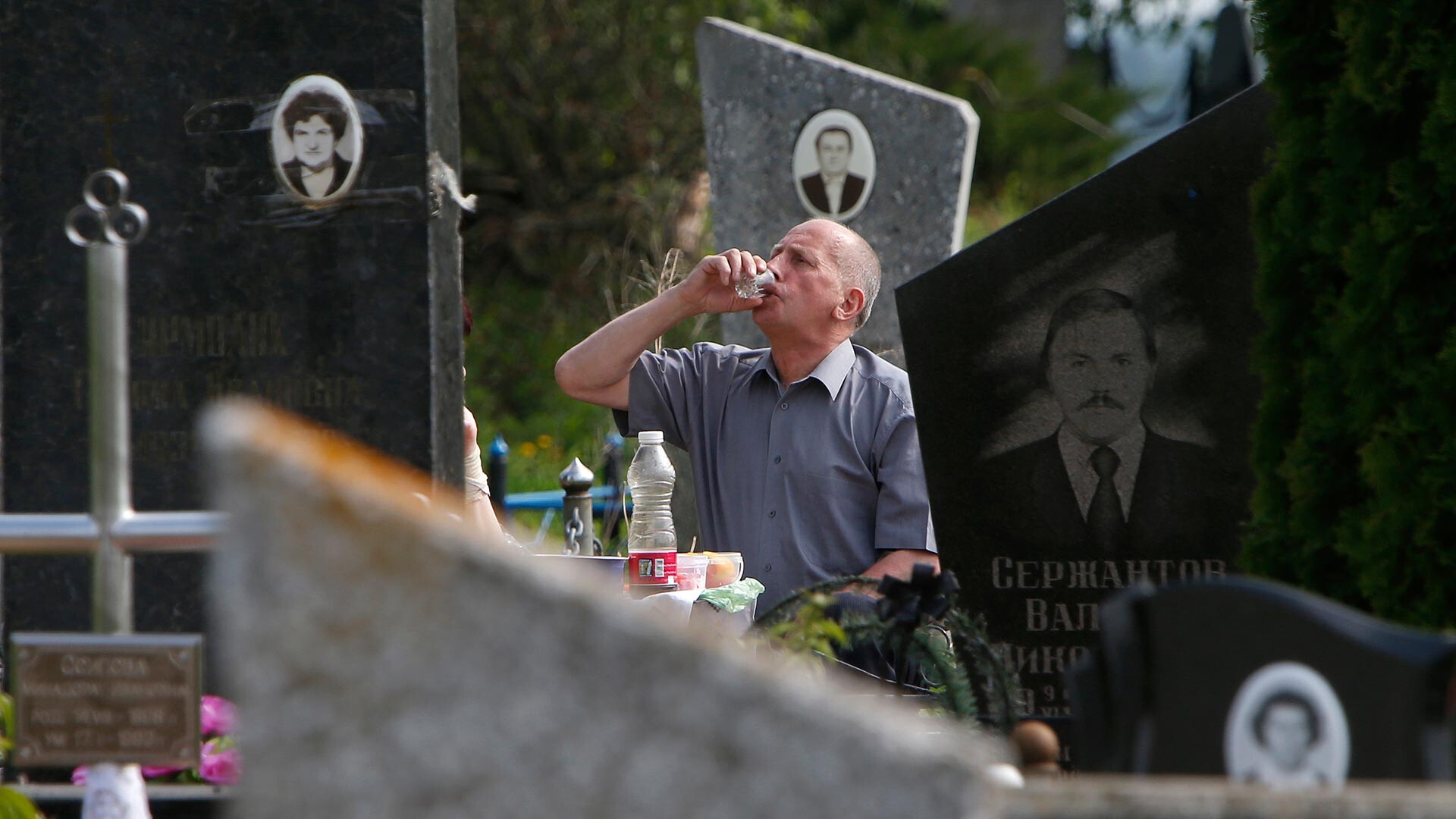 Seorang pria minum di kuburan selama perayaan Radonitsa.
