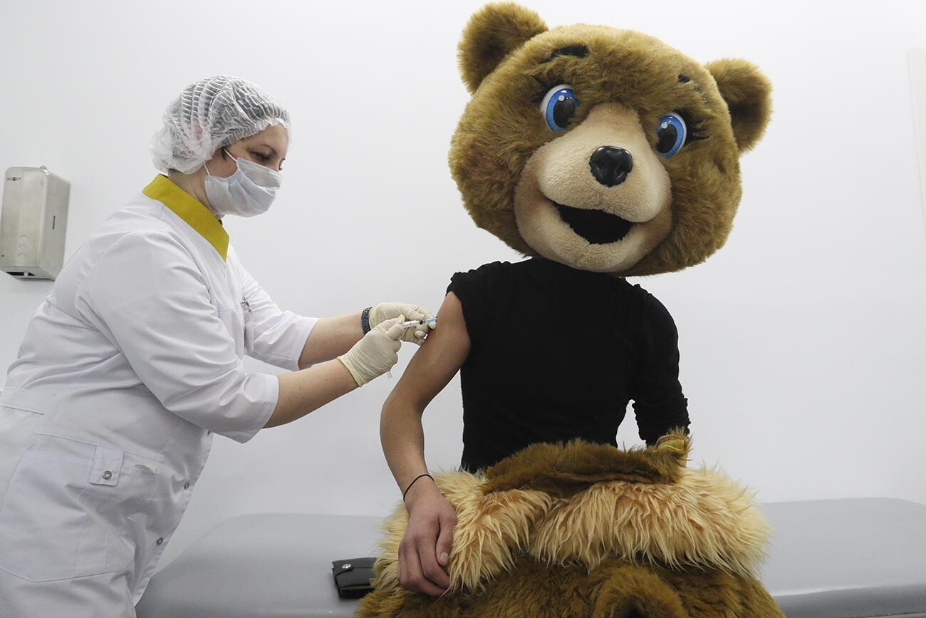 Медицинска сестра и аниматор тржног центра у костиму медведа за време вакцинације првом компонентом вакцине „Гам-КОВИД-Вак“ (трговачка марка „Спутник V“), у привременој амбуланти за вакцинацију у тржном центру „Шчолковски“.