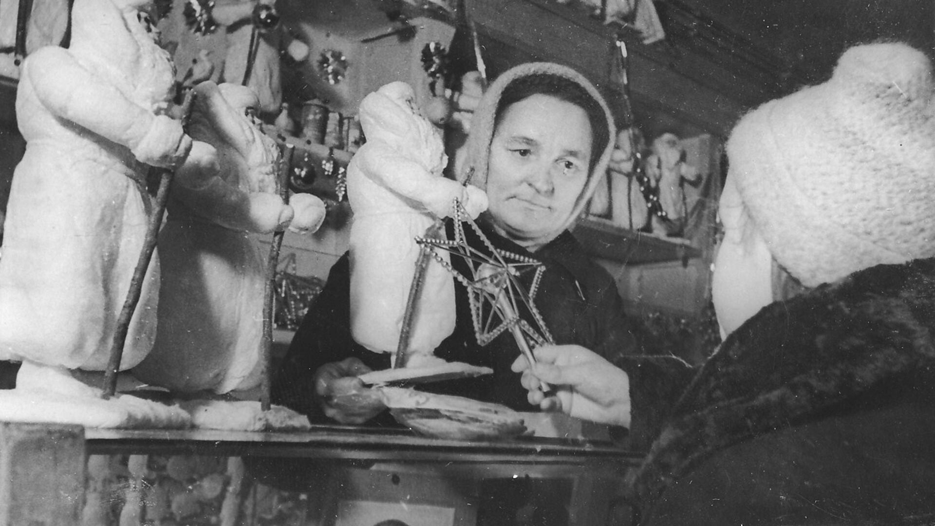 Vendedora de brinquedos mostra a uma jovem cliente enfeites para a árvore de Natal em 1942.