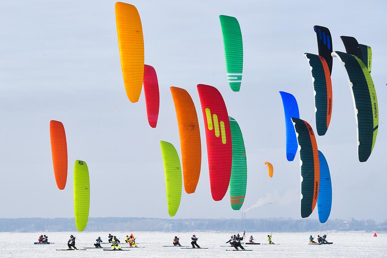 Athletes with kites during a race in the course-flight discipline at the Siberian Cup in winter sailing disciplines on the ice of the Novosibirsk Hydroelectric power Station reservoir