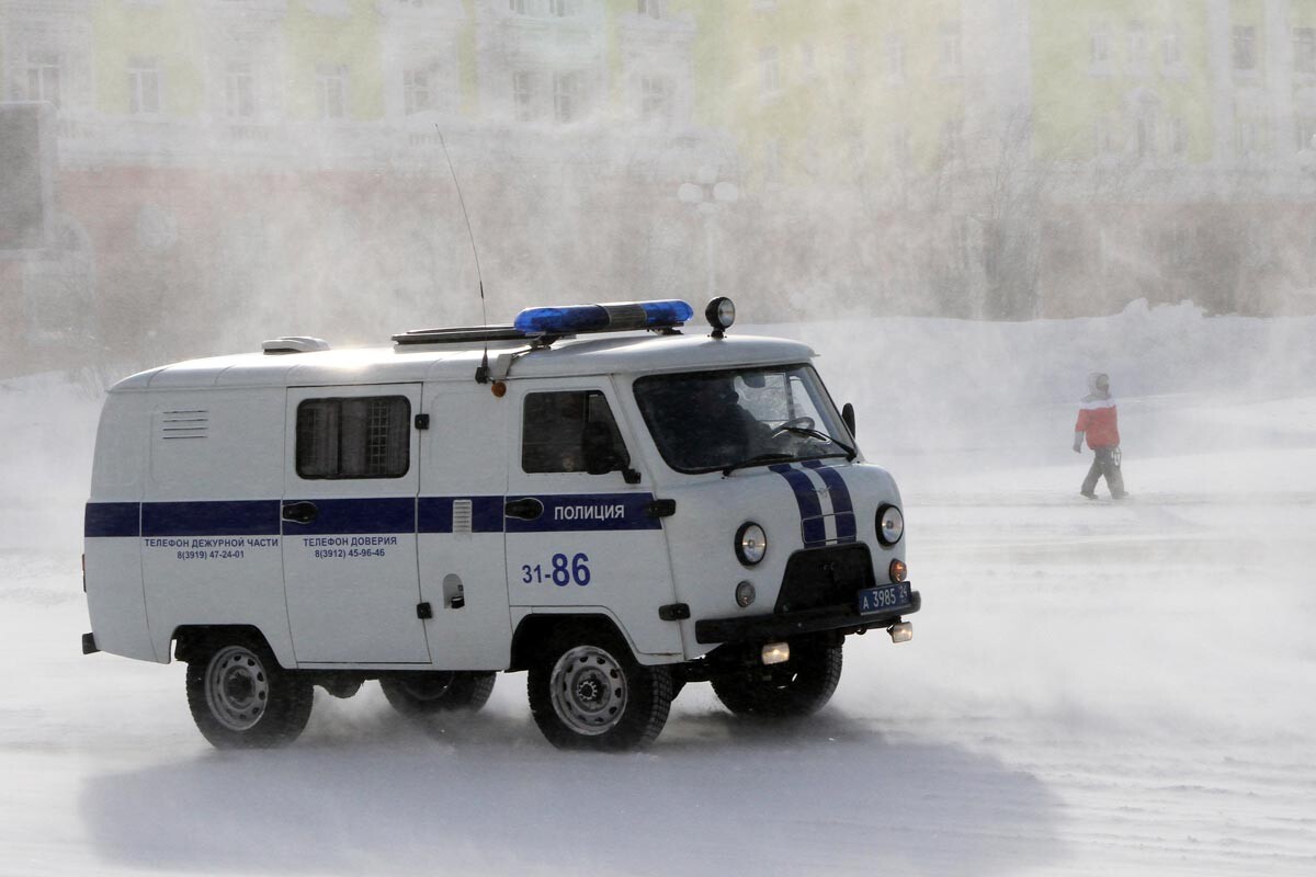 Норильск. Полицейский автомобиль на одной из улиц во время ветреной погоды. 