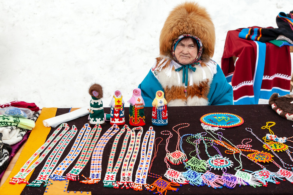 Seorang perempuan Khanty dalam pakaian tradisional yang menjual suvenir.