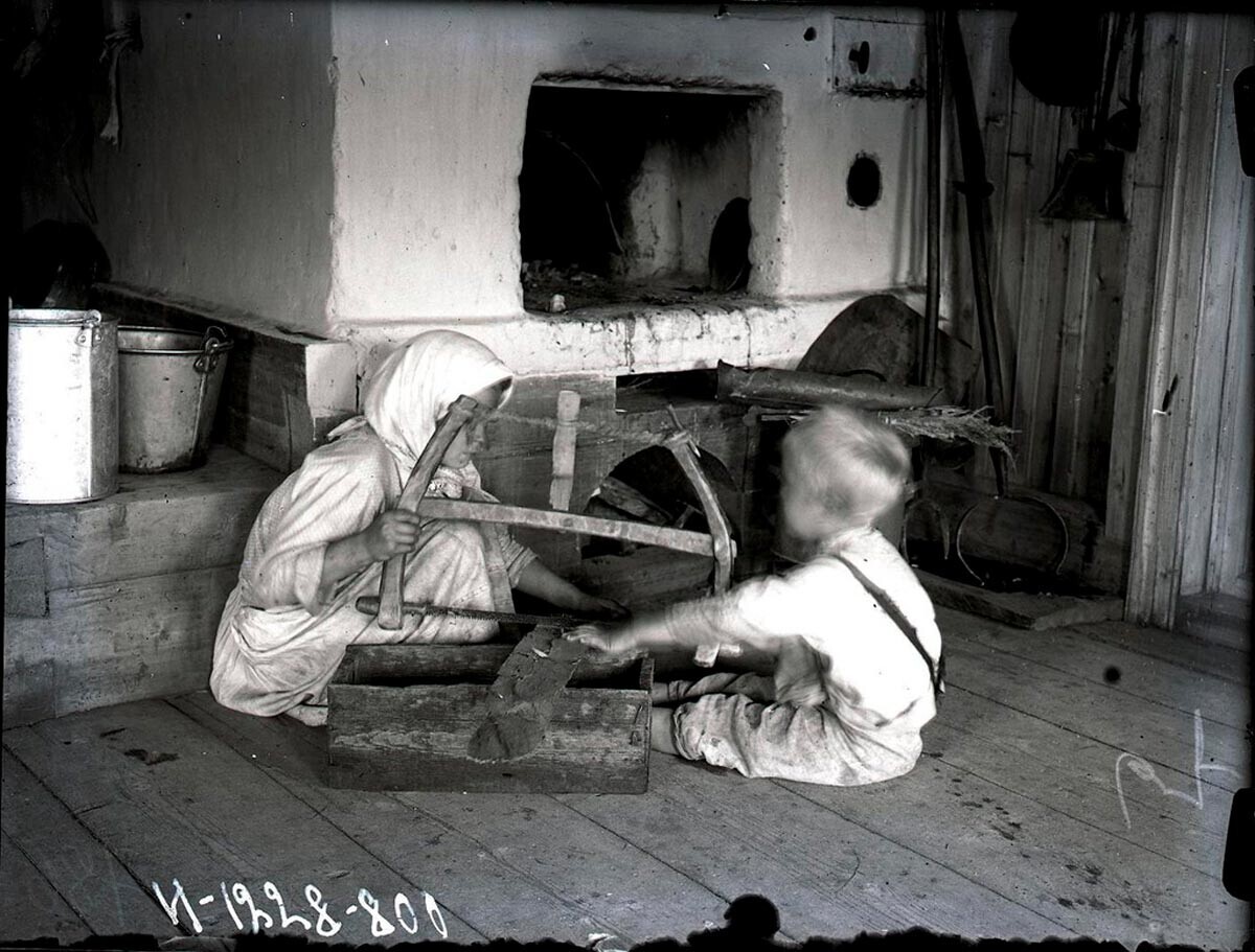 Pomoč staršem v gospodinjstvu: otroka, ki žagata drva, 1927 