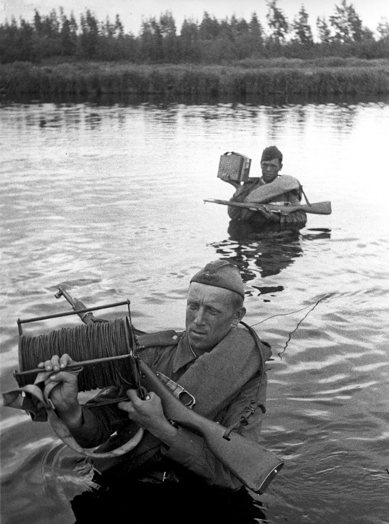 Des signaleurs soviétiques mènent une ligne de communication à travers la rivière durant la Grande Guerre patriotique de 1941-1945.