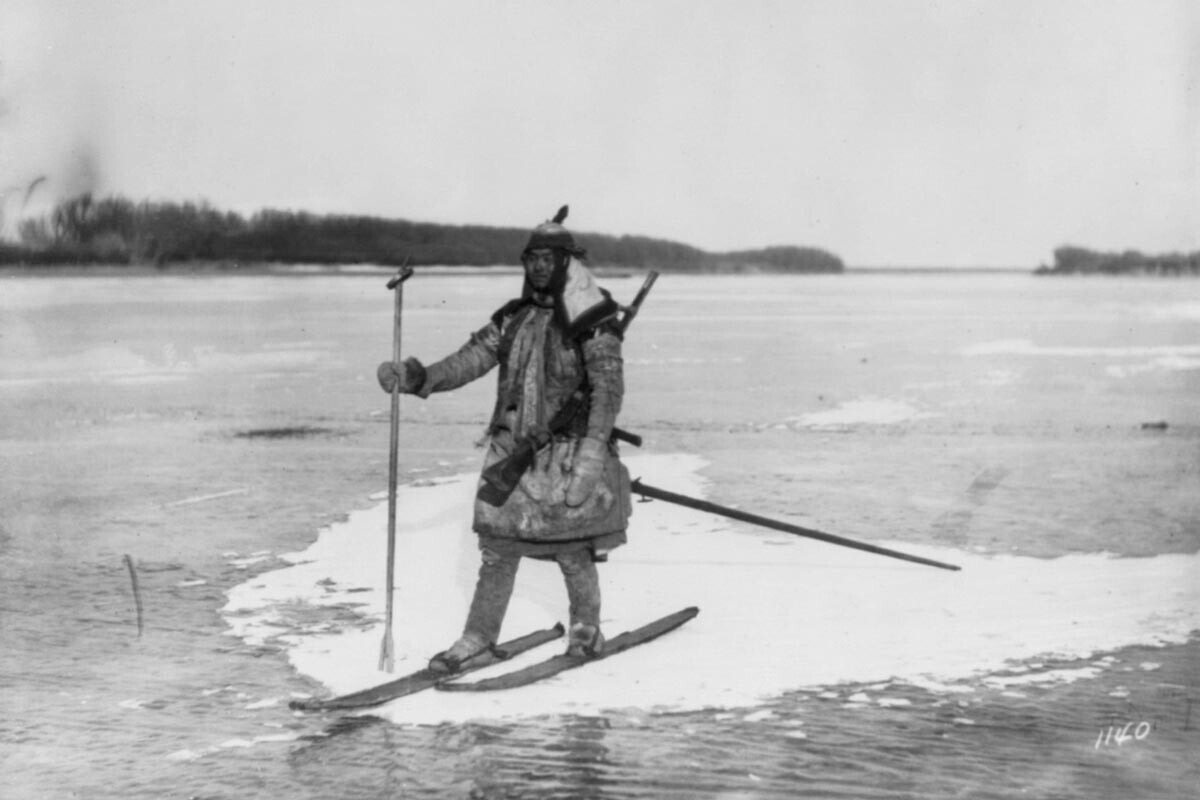Caçador em esquis no bloco de gelo, com lança e rifle

