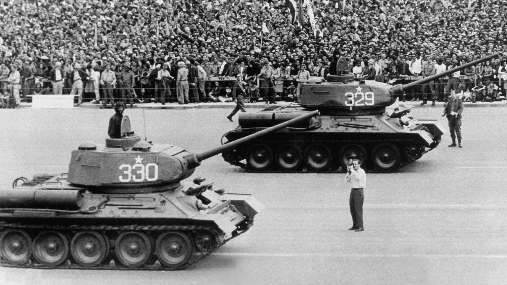 Tanques construidos en Rusia ruedan por la Plaza José Martí en presencia de miles de civiles con banderas en el tercer aniversario de la revolución cubana.
