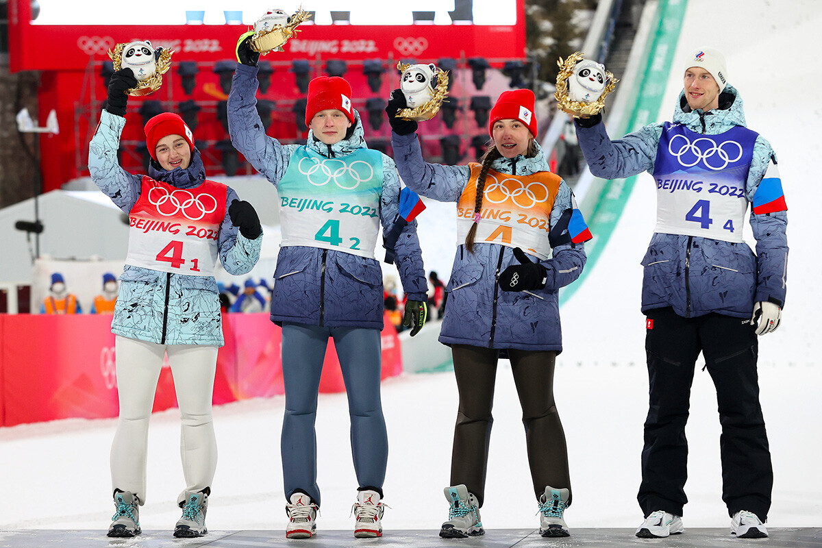 Ирма Махина, Данил Садреев, Ирина Авакумова и Евгениј Климов од тимот на Рускиот олимписки комитет го слават сребрениот медал во текот на церемонијата на доделување на награди и цвеќе во екипна конкуренција во мешан тим во Националниот центар за скијачки скокови на 7 февруари 2022, Жангјаку, Кина.
