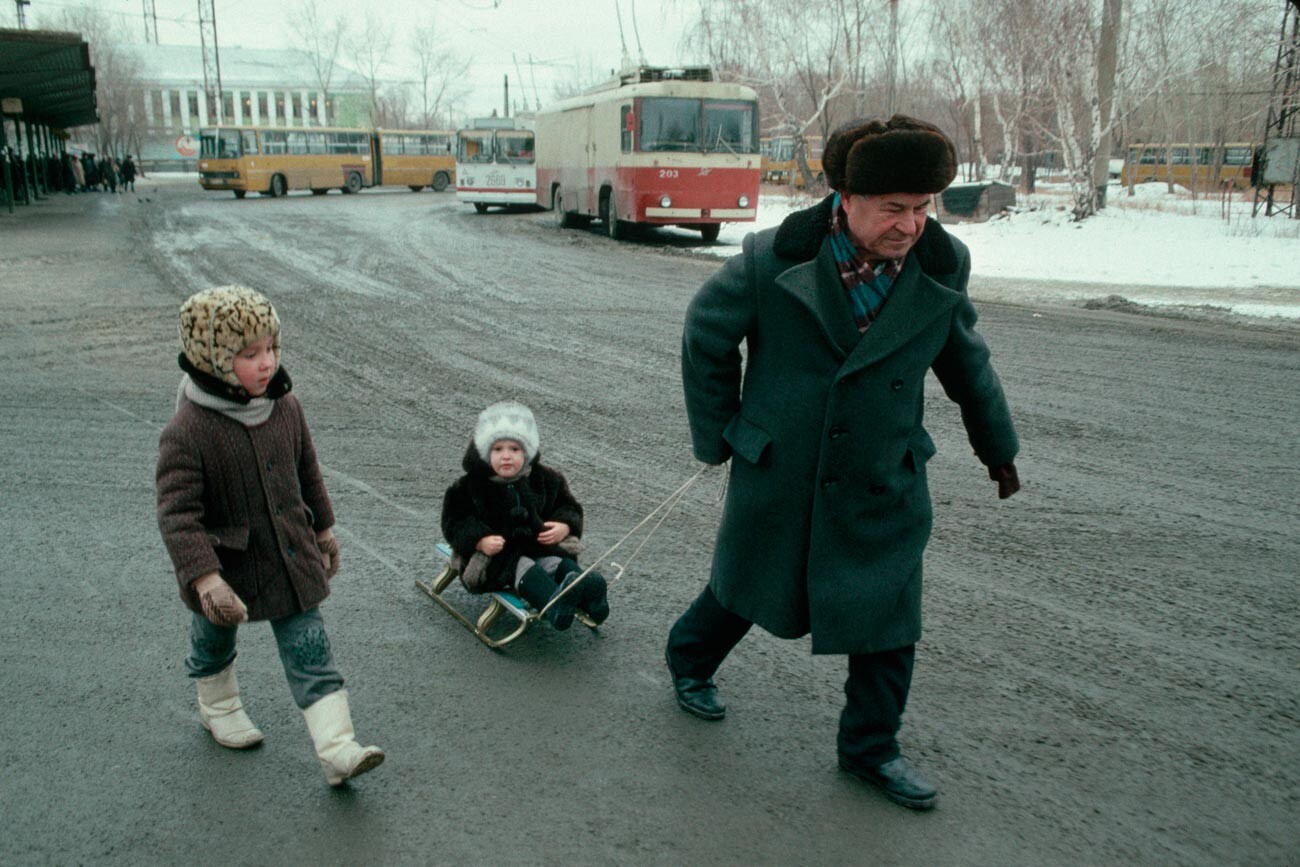 Man Pulling Children on a sled.