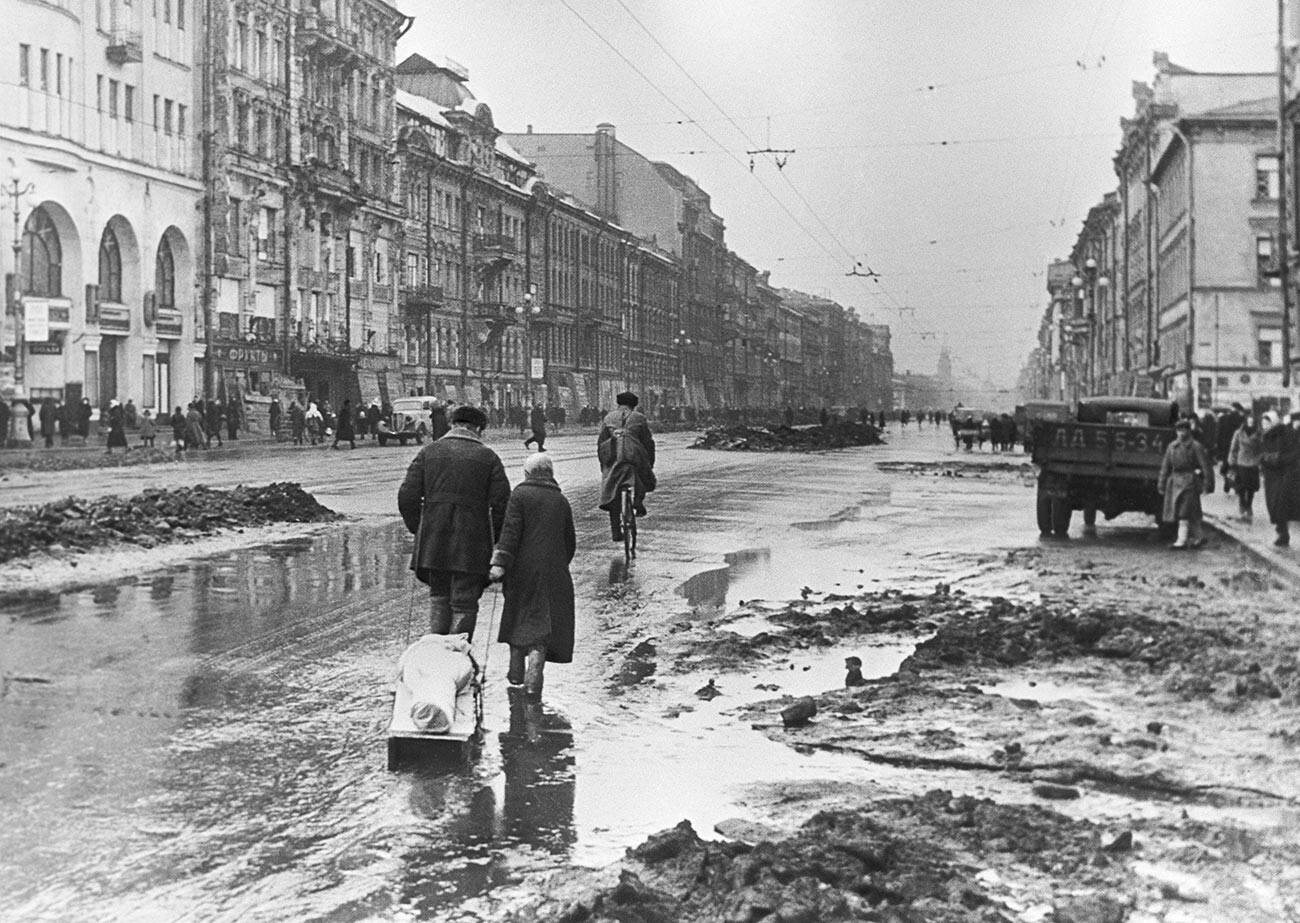 Belagerung von Leningrad. Angehörige tragen einen hungernden Leningrader zum Friedhof.