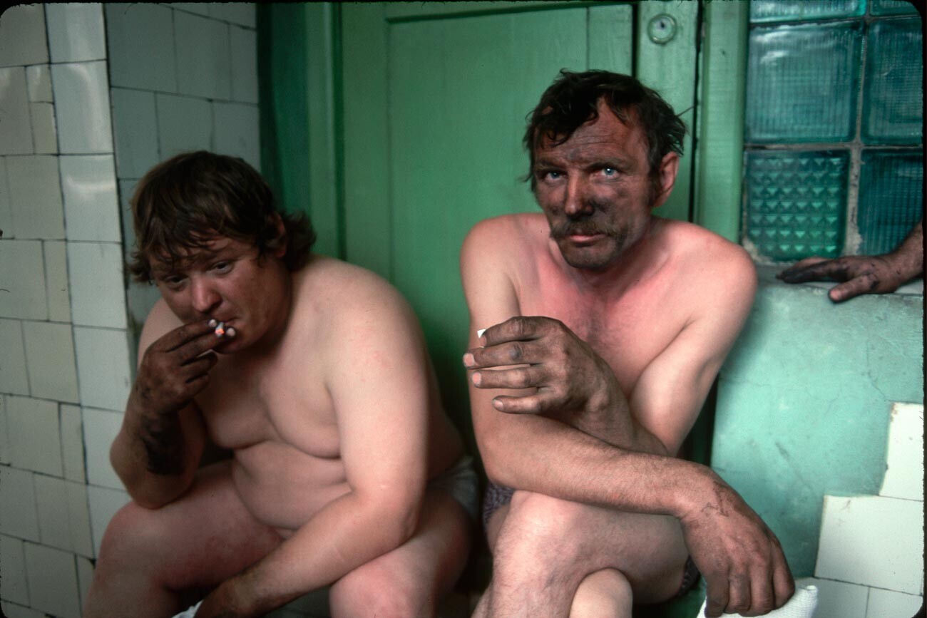 Dua penambang duduk di kamar mandi setelah giliran kerja mereka. Dua pekerja tersebut tinggal di kota pertambangan batu bara dan pabrik baja yang miskin dan mengalami kesulitan ekonomi yang sedang tersebar luas.